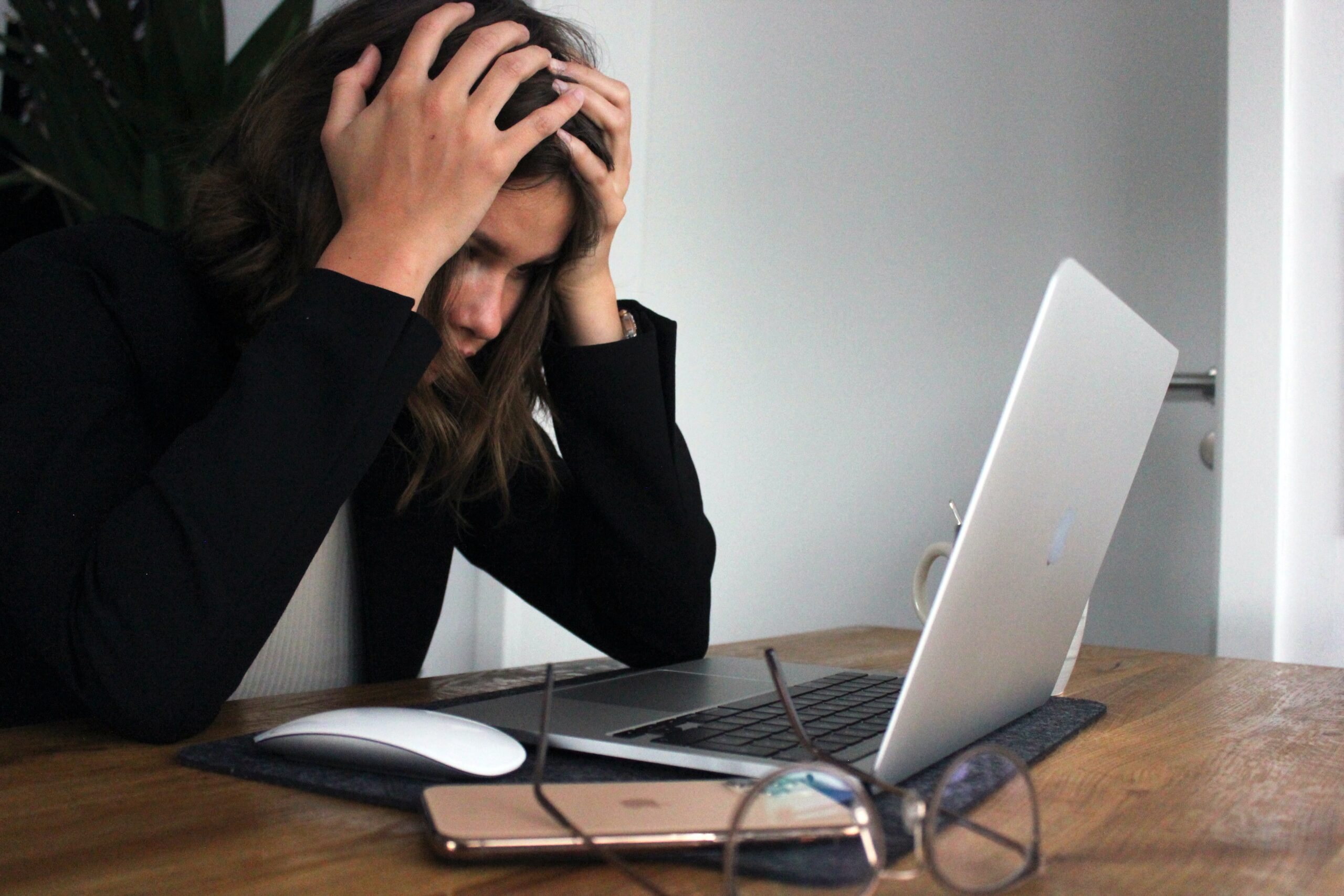 Girl with head in hand staring confused at a laptop screen