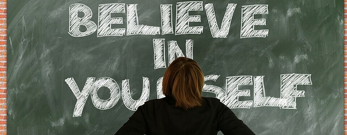 lady staring at a board with believe in yourself written on