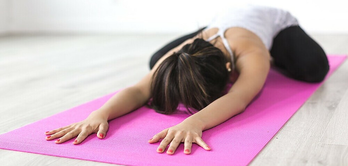 Lady on the mat in a baby pose stretching